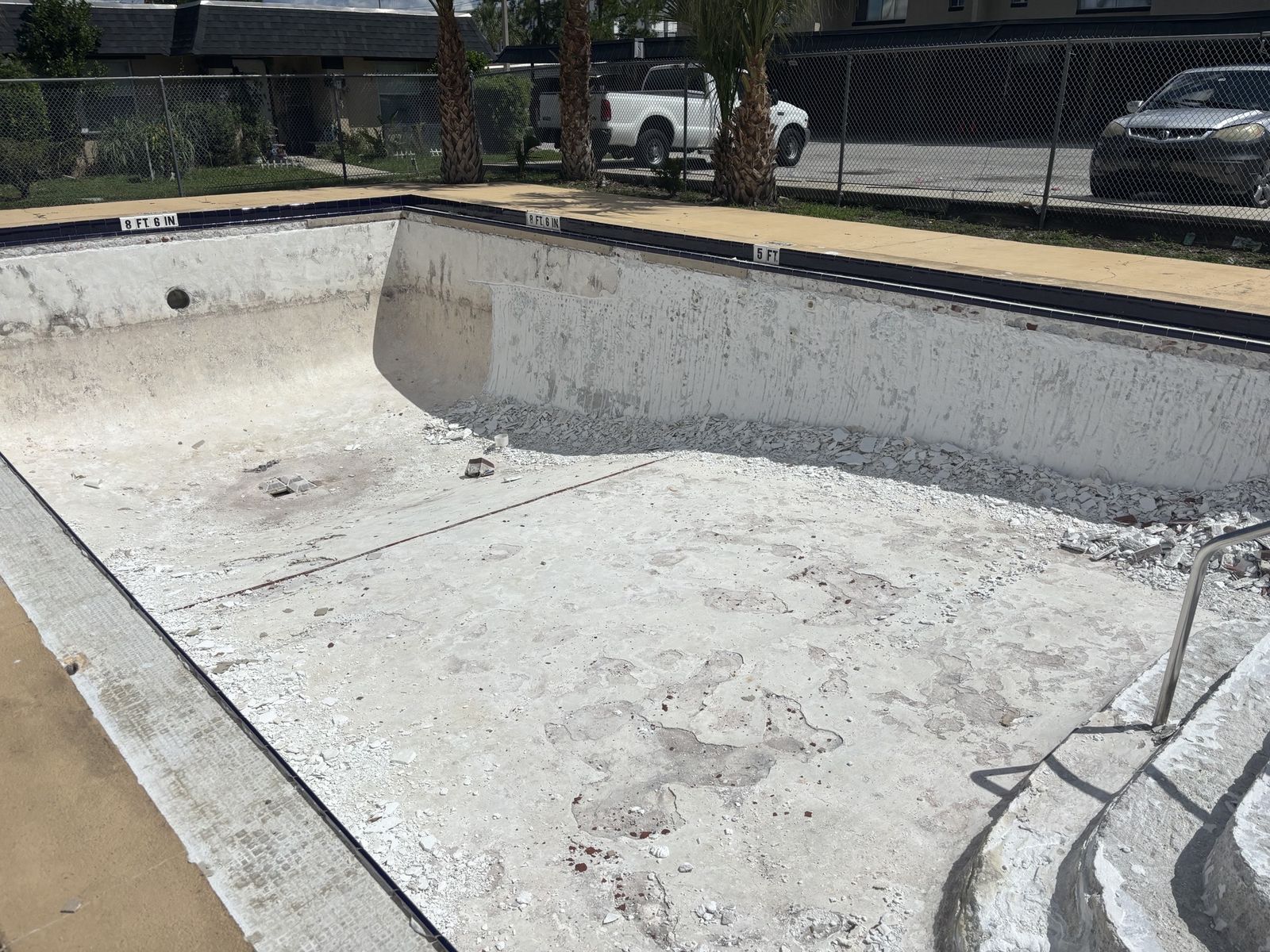 Drained commercial pool with worn, chipped plaster