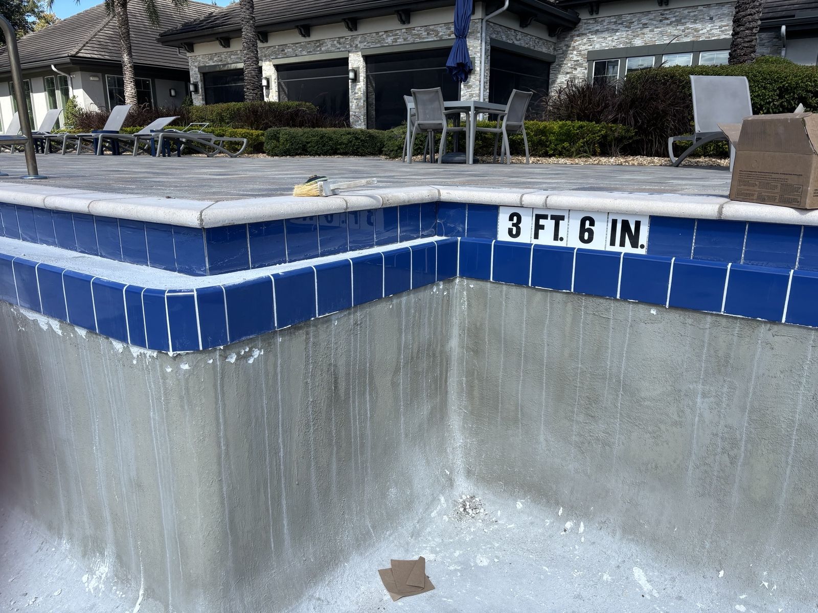 New blue waterline tile with a 3 ft 6 in depth marker on a drained pool